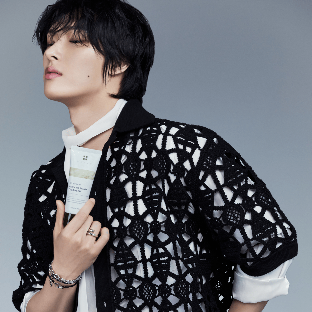 an ATEEZ member holding BRMUD Relief Mud Pack-to-Foam Cleanser – Korean 2-in-1 mud skincare product for deep cleansing